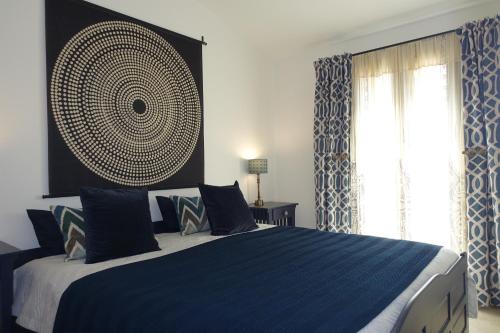 a bedroom with a blue and white bed with a window at Little sea town apartment in La Ciaccia