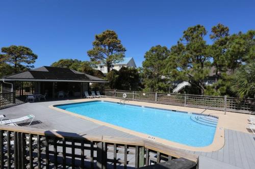 a swimming pool on a deck next to a house at Woofs and Waves by Pristine Properties Vacation Rentals in Cape San Blas