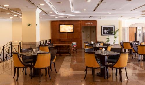 a restaurant with tables and chairs in a room at Monreale Plus Midtown Campinas in Campinas