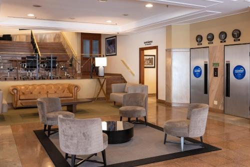 a waiting room with chairs and a couch and a table at Monreale Plus Midtown Campinas in Campinas