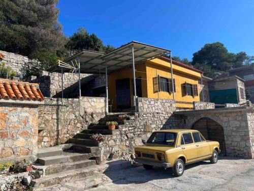 a yellow car parked in front of a house at Holiday home Ante in Žirje