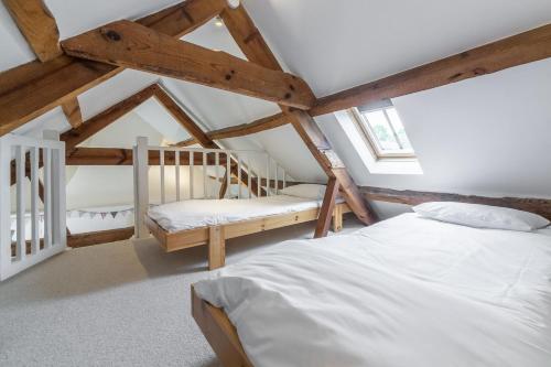 een slaapkamer met 2 bedden op een zolder bij Jasmine Cottage 4 in South Creake