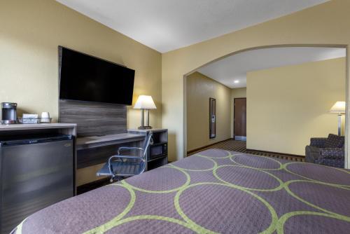 a hotel room with a bed and a flat screen tv at Super 8 by Wyndham Nixa/Springfield Area in Nixa