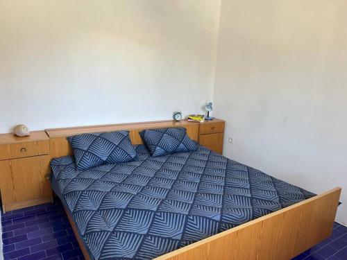 a bedroom with a bed with a blue comforter at Holiday home Ante in Žirje