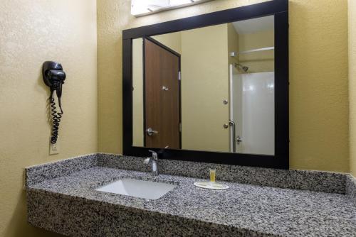 a bathroom sink with a mirror and a phone at Super 8 by Wyndham Nixa/Springfield Area in Nixa