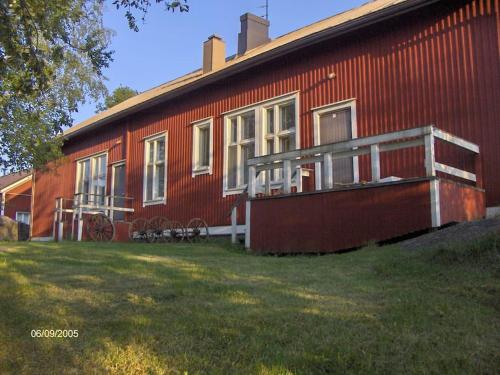 uma casa vermelha com um grande quintal em frente em Maaseutumajoitus, Kesti-Iivarin Majatalo em Ylistaro