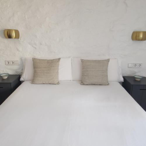 a white bed with two pillows on top of it at Hostal Blavet in Calaceite