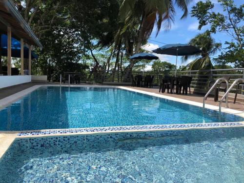 a large blue swimming pool with a table and umbrella at La Manola Finca Hotel in Doradal