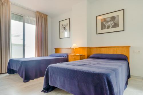 een hotelkamer met 2 bedden en een raam bij Casas Fuente del Sol in Conil de la Frontera