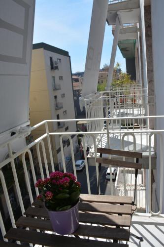 a balcony with two chairs and a vase of flowers at La Dimora in Catania