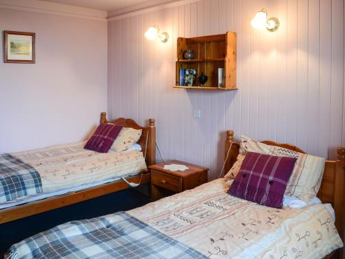 a bedroom with two beds and a night stand at Farr in Helmsdale