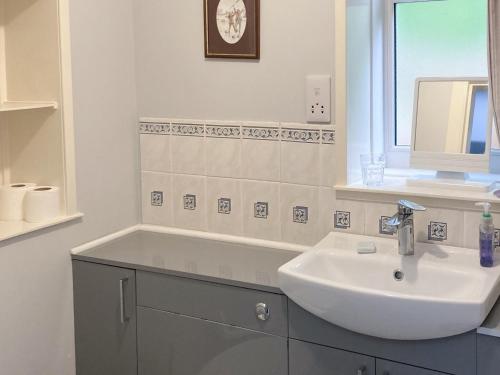 bagno bianco con lavandino e specchio di Farr a Helmsdale