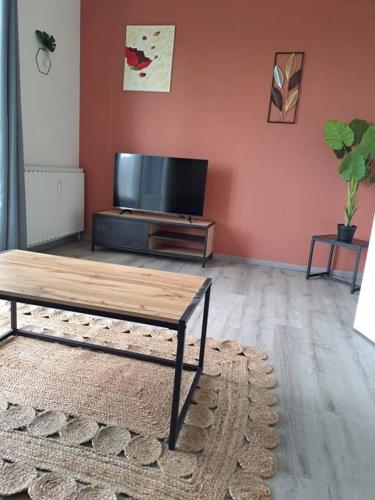 a living room with a table and a tv at Agréable T2 Classé 3 étoiles, refait à neuf, dans quartier calme in Rodez