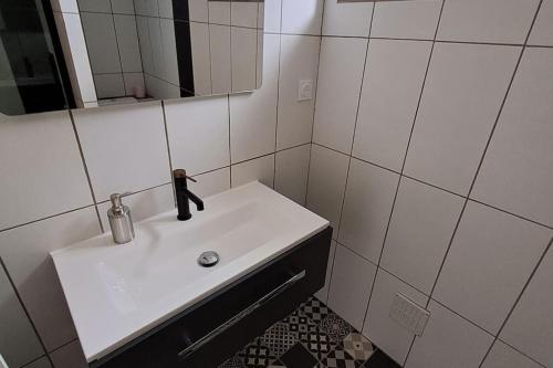 a bathroom with a white sink and a mirror at Agréable T2 Classé 3 étoiles, refait à neuf, dans quartier calme in Rodez
