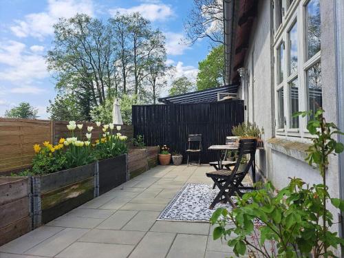 een patio met een tafel en stoelen en een hek bij Hyggelig ferielejlighed i Harresø in Give