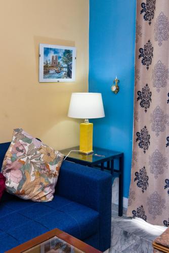 a blue living room with a blue couch and a lamp at The Pearl Apartment Hammam Sousse WIFI in Sousse