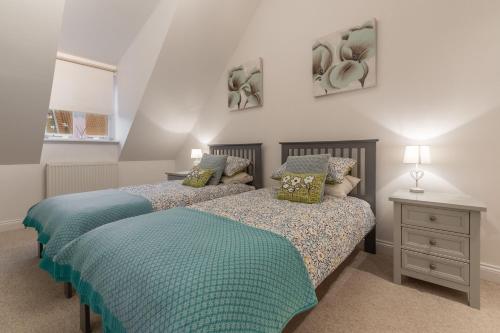 two beds sitting next to each other in a bedroom at The Moorings in Wells next the Sea