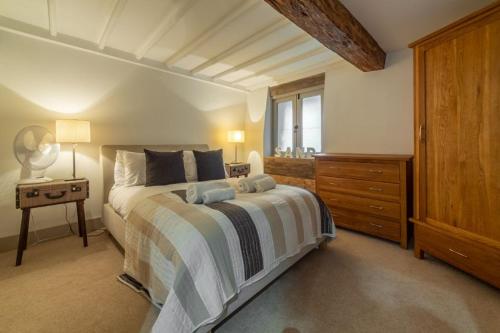 a bedroom with a bed with a dresser and a window at Hideaway Barn 4 in Thornham