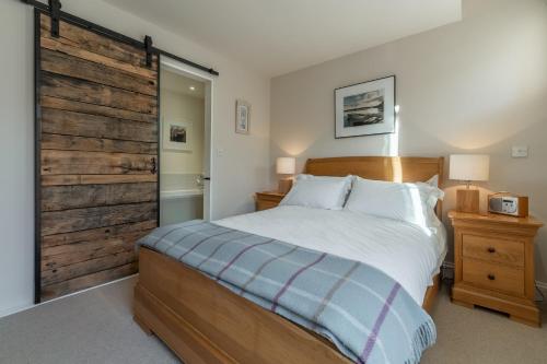 a bedroom with a bed and a sliding barn door at The Little Barn in Ringstead