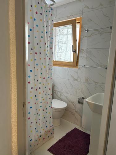 a bathroom with a toilet and a shower curtain at Studio Lac Noir in Chandolin