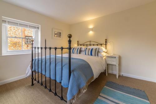 a bedroom with a bed and a window at Sea Holly House in Blakeney