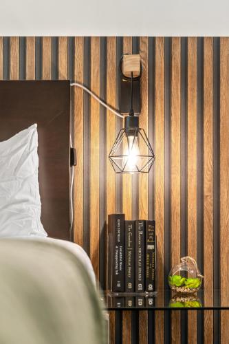 a lamp on a table next to a bed at The Mountaineer by InstantSuites Pool & HotTub in Canmore