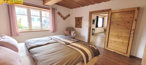 1 dormitorio con 1 cama y puerta de madera en Klampfner Gütl by FiS - Fun in Styria en Altaussee