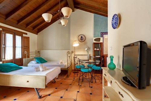 1 dormitorio con 2 camas, TV y mesa en Charminghomesgranada Apartamento Río Genil, en Granada