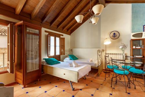 1 dormitorio con 2 camas, mesa y sillas en Charminghomesgranada Apartamento Río Genil, en Granada