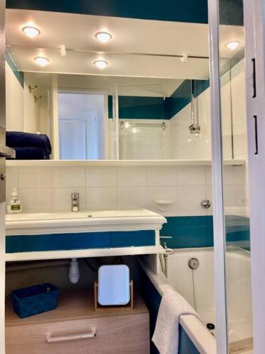 une salle de bain avec un lavabo, une baignoire et un miroir dans l'établissement Les Restanques bougainvillée 2051, à Grimaud