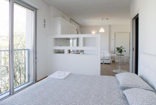 sypialnia z łóżkiem i dużym oknem w obiekcie Housing32 Apartments w Mediolanie