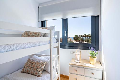 1 dormitorio con literas y ventana en Apartamento El Castillo, en Roquetas de Mar