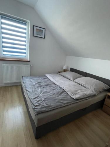 een bed in een slaapkamer met een raam bij Całoroczny domek - bliźniak 