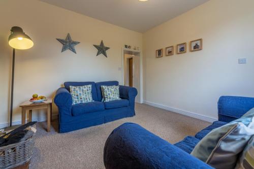 a living room with two blue chairs and stars on the wall at 2 Providence Place in Thornage