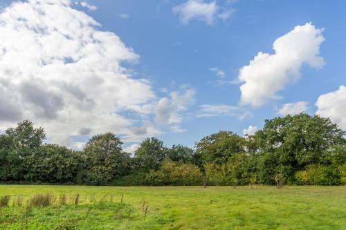 a green field with trees and a cloudy sky at 2 Providence Place in Thornage