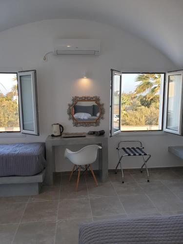 - une chambre avec un bureau, un lit et un miroir dans l'établissement ILIADA-ODYSSEAS RESORT, à Perivolos