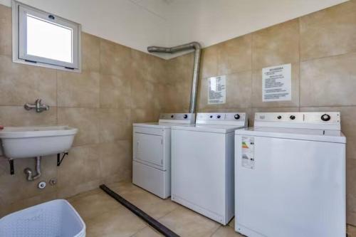 baño con 2 lavadoras y lavamanos en Hermoso Studio en Recoleta con Piscina y Laundry en Buenos Aires