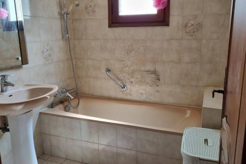 une salle de bain avec un lavabo et une baignoire et un lavabo dans l'établissement maison rez de jardin 2 à 4 personnes, au Lavandou