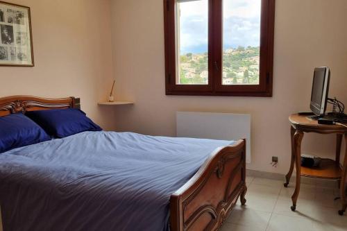 une chambre avec un lit, un bureau et une fenêtre dans l'établissement maison rez de jardin 2 à 4 personnes, au Lavandou
