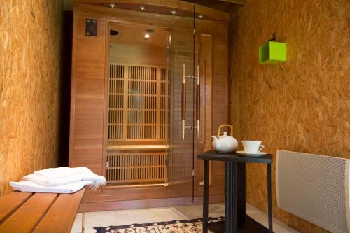 a bathroom with a shower and a table with a vase on it at Maison d'Hotes ZEN 