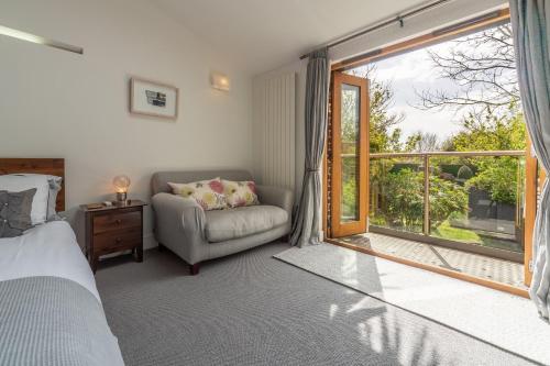 1 dormitorio con cama, ventana y sofá en Sybil Cottage 4, en Holme next the Sea