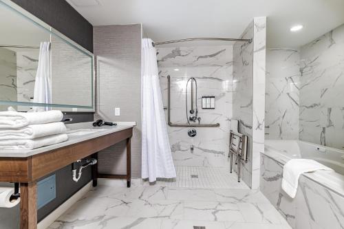 a bathroom with a shower and a tub and a sink at Hyatt Place Toronto-Brampton in Brampton