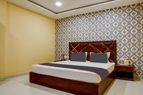 ein Schlafzimmer mit einem Bett und einer Wand in der Unterkunft Collection O Blue Diamond in Allahabad