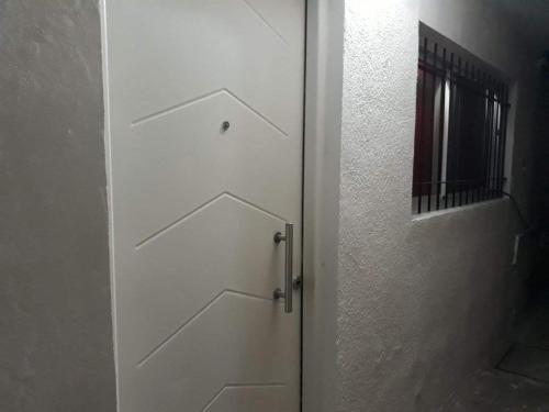 a white door withdrawers on the side of a room at Dpto económico para tres en Ballester con TV in Villa Ballester
