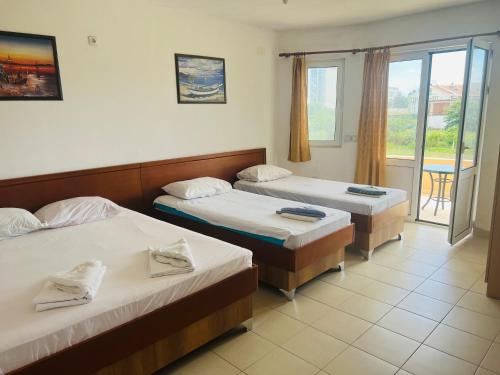 a hotel room with two beds and a balcony at Apartments Betti in Ulcinj