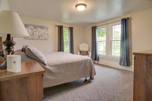 a bedroom with a bed and a desk and windows at Waterfront Home with Hot Tub in Wrightsville! in Wrightsville