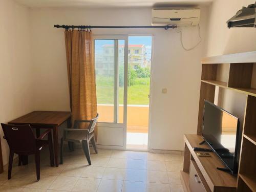 a living room with a dining room table and a window at Apartments Betti in Ulcinj