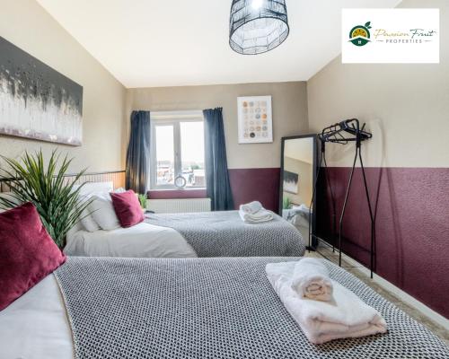 una camera con due letti e un bambino steso sul pavimento di 3 BedRoom House with 5 Beds House By Passionfruit Properties Near Coventry City Centre - BCC a Coventry