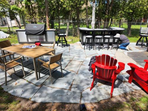 a patio with chairs and tables and a man sitting on the ground at Captain Dan's Shanty in Saint Andrews