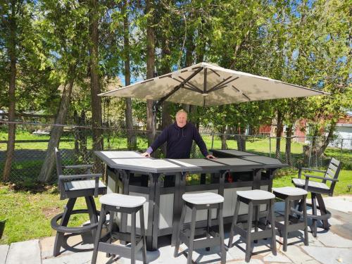 a man sitting at a table with an umbrella at Captain Dan's Shanty in Saint Andrews